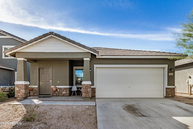 view of front of house featuring a garage, stone siding, and stucco siding