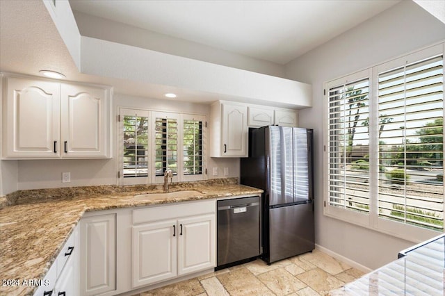 kitchen featuring baseboards, stone tile flooring, a sink, white cabinets, and appliances with stainless steel finishes