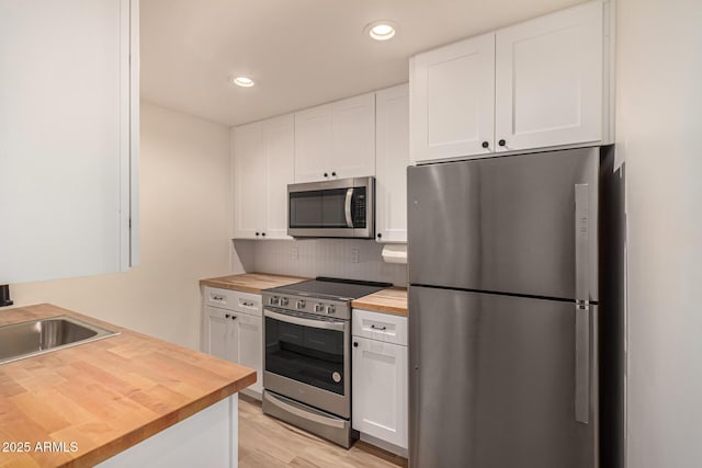 461 W Holmes Ave Unit 323, Mesa, AZ 85210 - kitchen featuring butcher block countertops, stainless steel appliances, white cabinets, backsplash, and recessed lighting