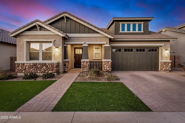 craftsman inspired home featuring a garage and a yard