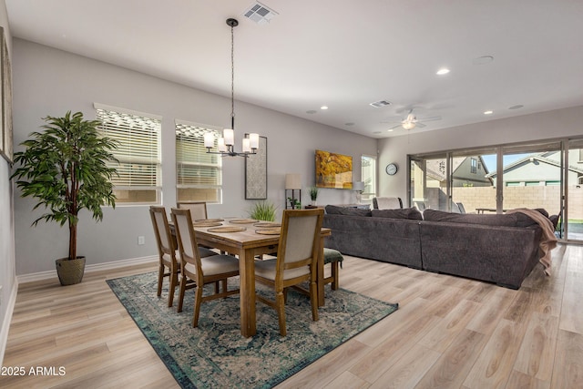 dining room featuring ceiling fan with notable chandelier and light wood-type flooring