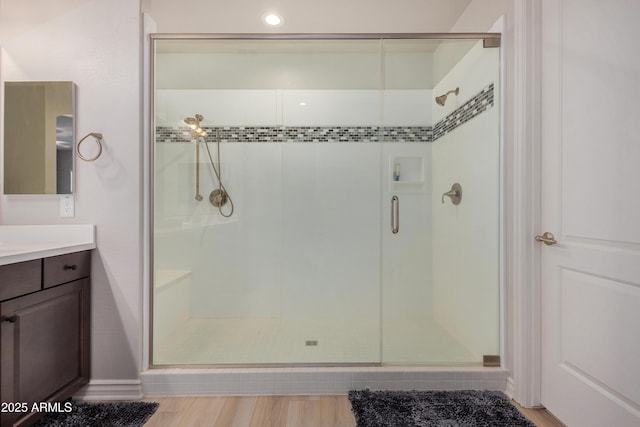 bathroom featuring vanity, a shower with shower door, and hardwood / wood-style floors