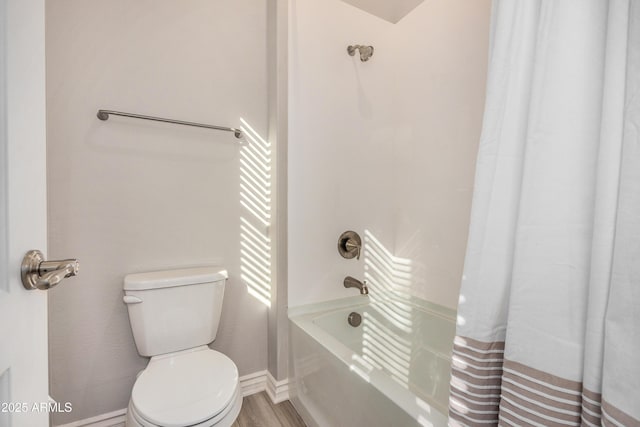 bathroom featuring toilet, shower / bath combo with shower curtain, baseboards, and wood finished floors