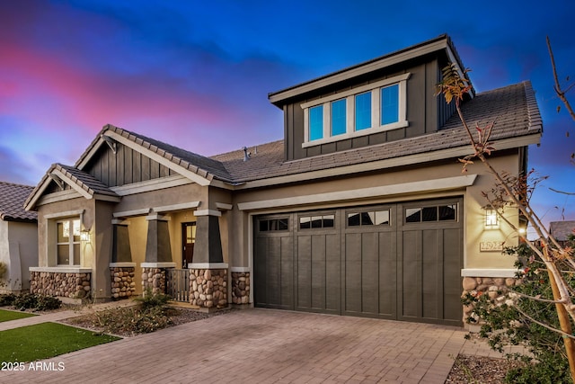 craftsman inspired home featuring stone siding, board and batten siding, a tile roof, and decorative driveway