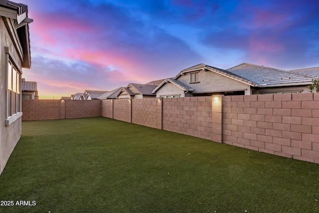 yard at dusk with a fenced backyard