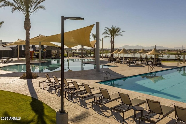 view of swimming pool with a water view and a patio