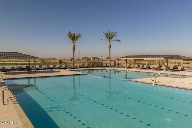 community pool with a patio area and fence