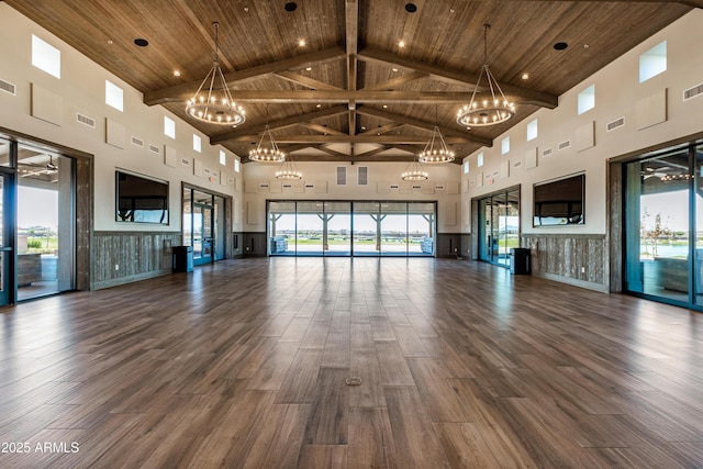 unfurnished living room with a notable chandelier, wood ceiling, and high vaulted ceiling