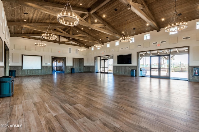 unfurnished living room with a chandelier, visible vents, wooden ceiling, and wood finished floors