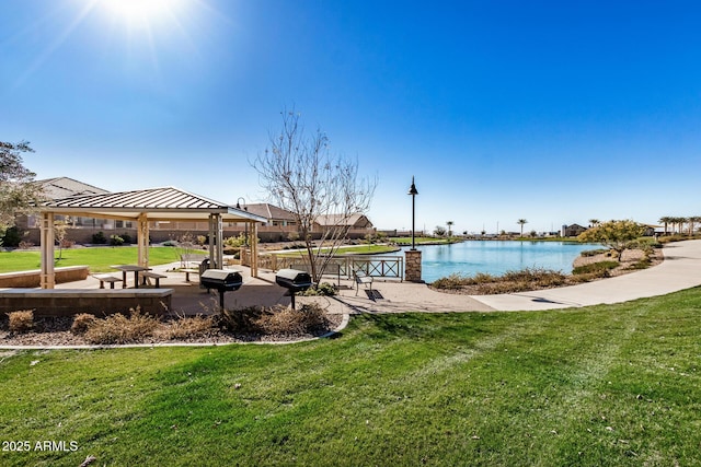 view of community with a gazebo, a yard, and a water view