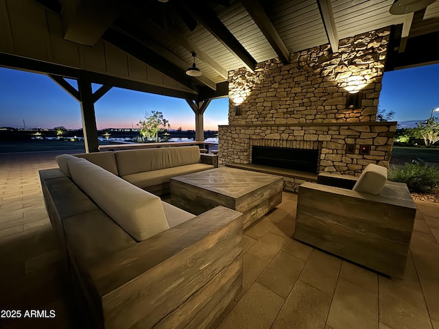 patio terrace at dusk with an outdoor living space with a fireplace