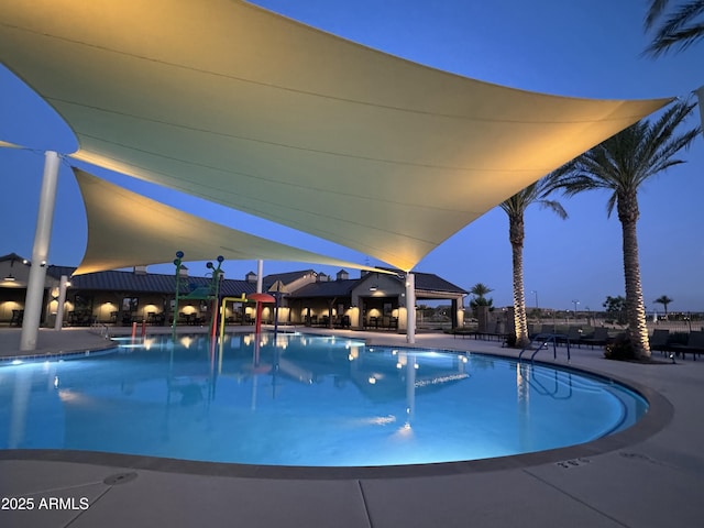 pool at dusk featuring a patio