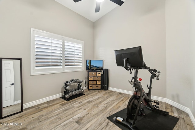 workout room featuring lofted ceiling, ceiling fan, and light wood-type flooring