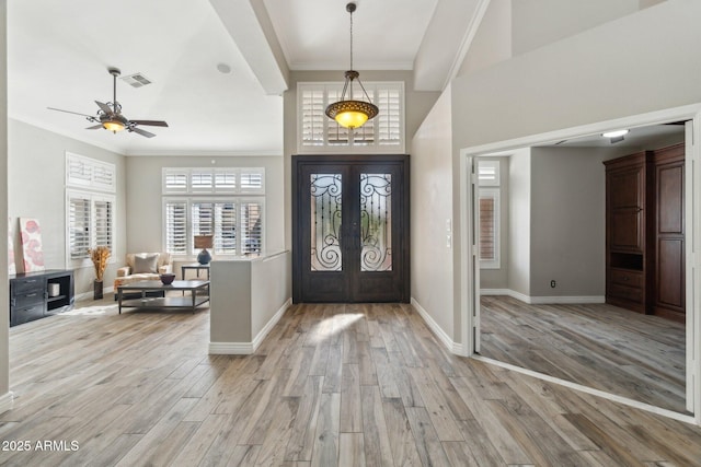 foyer entrance with french doors, ornamental molding, ceiling fan, and light hardwood / wood-style flooring