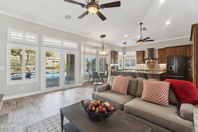 living room featuring crown molding, light hardwood / wood-style flooring, and ceiling fan