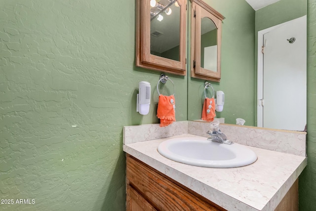 bathroom with a textured wall and vanity