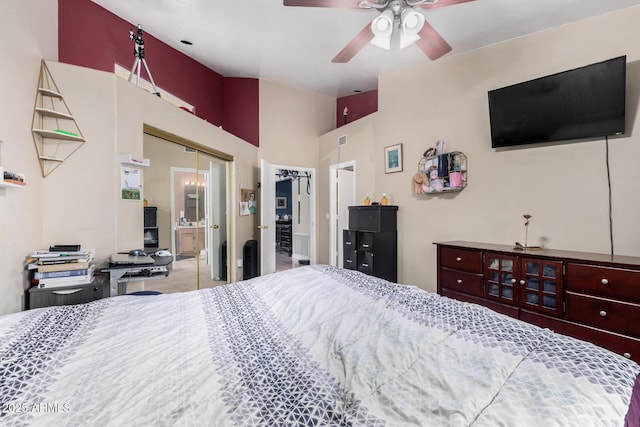 bedroom featuring lofted ceiling, a ceiling fan, a closet, and ensuite bathroom