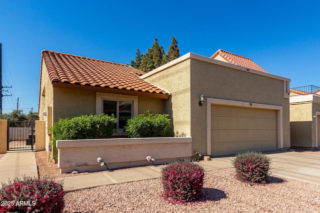 mediterranean / spanish-style house with concrete driveway, a tile roof, an attached garage, and stucco siding