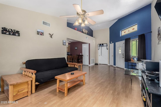 living area featuring light wood-style floors, visible vents, ceiling fan, and high vaulted ceiling