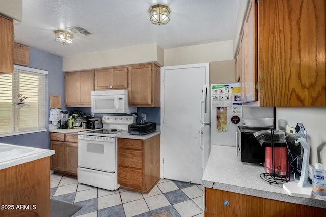 kitchen with light countertops, white appliances, visible vents, and brown cabinets