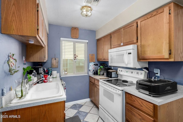 kitchen with brown cabinets, white appliances, and light countertops