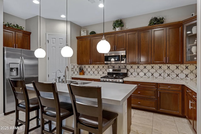 6694 S Banning St, Gilbert, AZ 85298 - kitchen featuring stainless steel appliances, a sink, backsplash, light countertops, and an island with sink