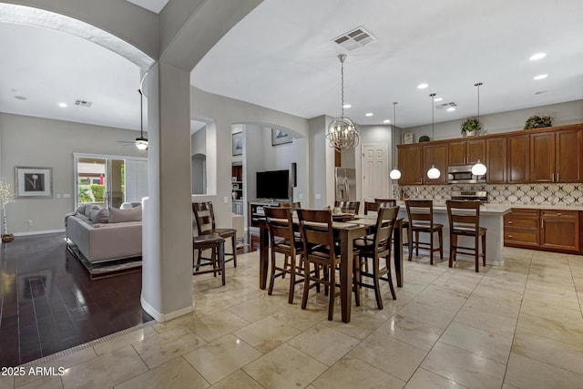 6694 S Banning St, Gilbert, AZ 85298 - dining space featuring ceiling fan with notable chandelier, baseboards, visible vents, and arched walkways