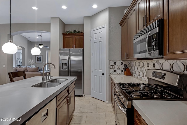 6694 S Banning St, Gilbert, AZ 85298 - kitchen with stainless steel appliances, arched walkways, a sink, tasteful backsplash, and hanging light fixtures