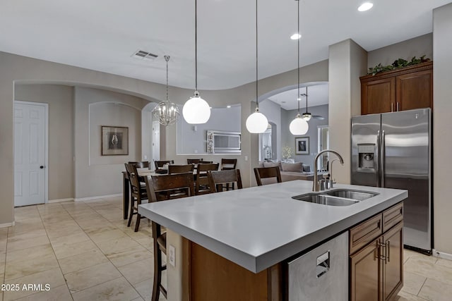6694 S Banning St, Gilbert, AZ 85298 - kitchen with an island with sink, a ceiling fan, a sink, arched walkways, and stainless steel fridge