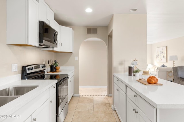 kitchen with white cabinetry, appliances with stainless steel finishes, and light tile patterned floors