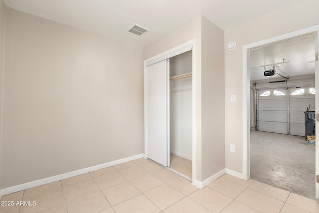 unfurnished bedroom with light tile patterned floors and a closet