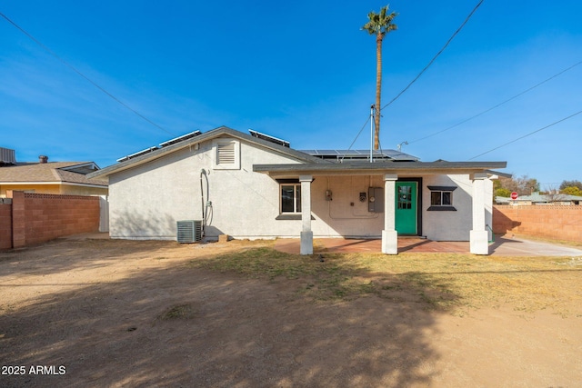 rear view of house featuring cooling unit and solar panels