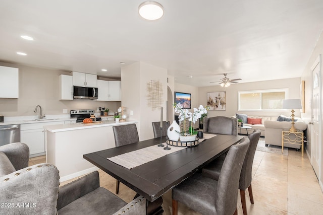 dining room featuring sink, light tile patterned floors, and ceiling fan