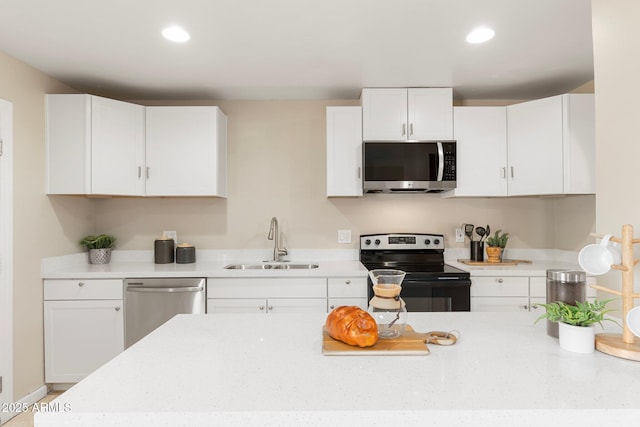 kitchen with sink, white cabinets, and appliances with stainless steel finishes