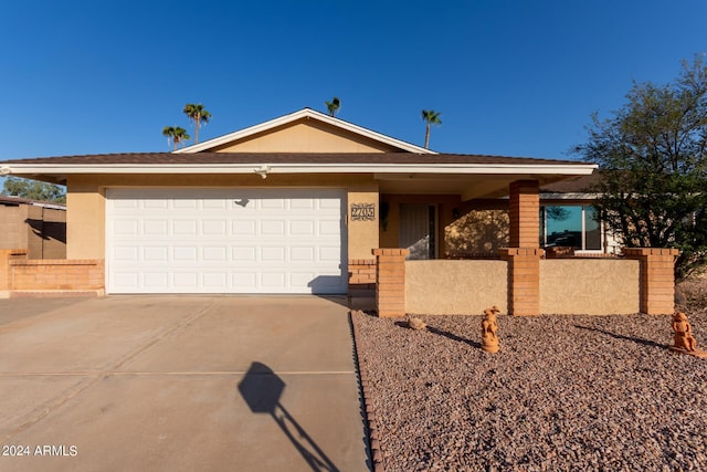single story home featuring concrete driveway, a garage, stucco siding, and a fenced front yard