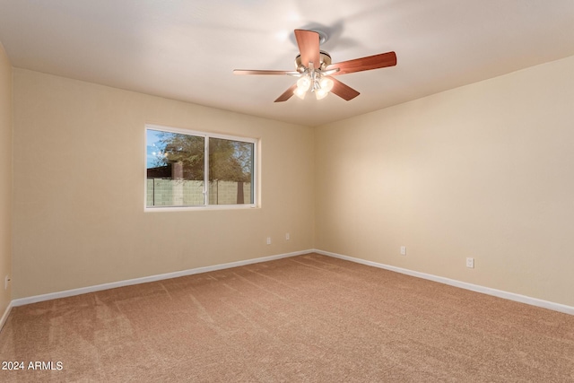 empty room with light colored carpet, ceiling fan, and baseboards