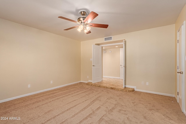 empty room featuring ceiling fan and light colored carpet