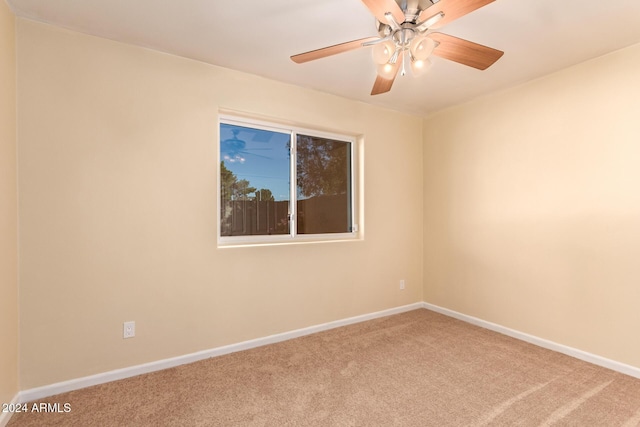 carpeted empty room with a ceiling fan and baseboards