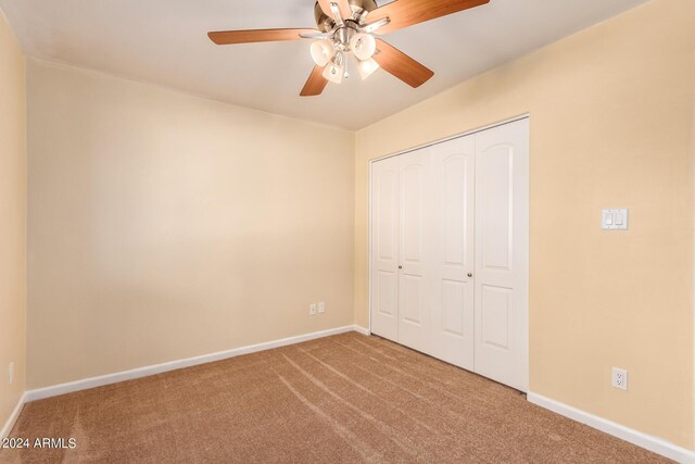 unfurnished bedroom featuring baseboards, a ceiling fan, carpet flooring, and a closet
