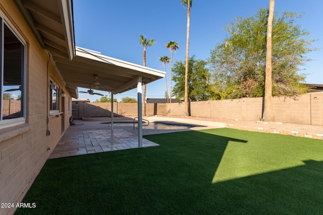 view of yard with a fenced backyard, a patio, and ceiling fan