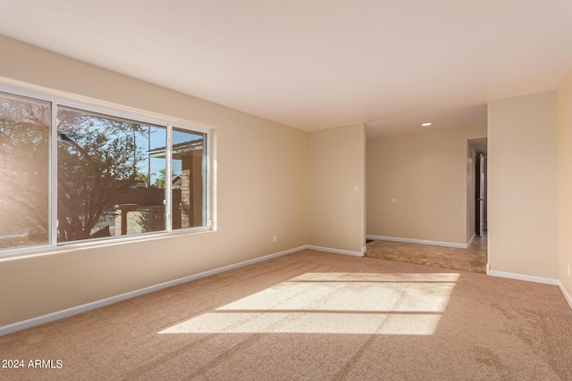 spare room with baseboards and carpet