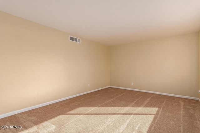 unfurnished room with baseboards, visible vents, and carpet