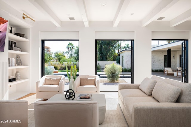 living room featuring beam ceiling, a wood stove, plenty of natural light, and built in shelves