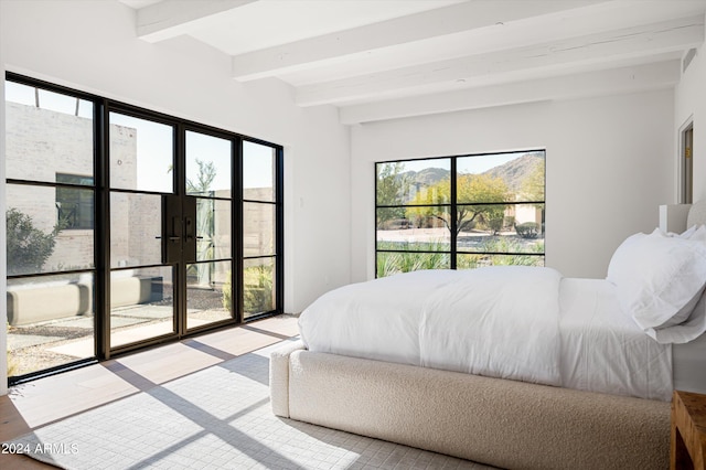 bedroom featuring beamed ceiling, french doors, and multiple windows