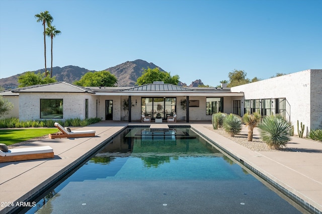 back of house with a mountain view and a patio