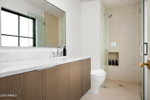 bathroom with tile patterned flooring, a tile shower, vanity, and toilet