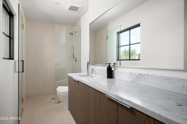 bathroom with tile patterned flooring, vanity, toilet, and a shower with shower door