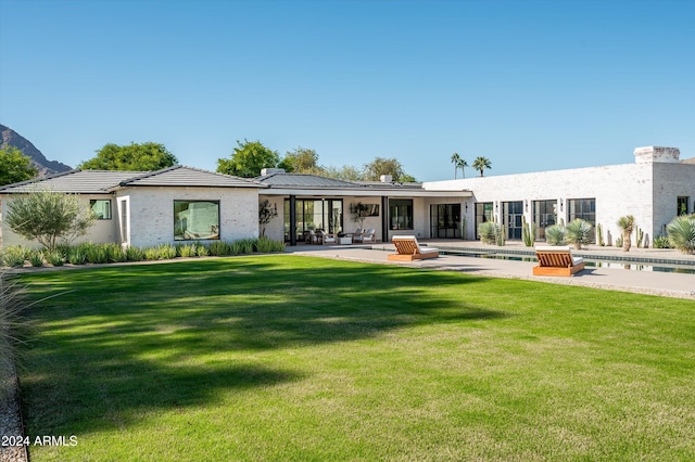 back of property featuring a lawn and a patio area