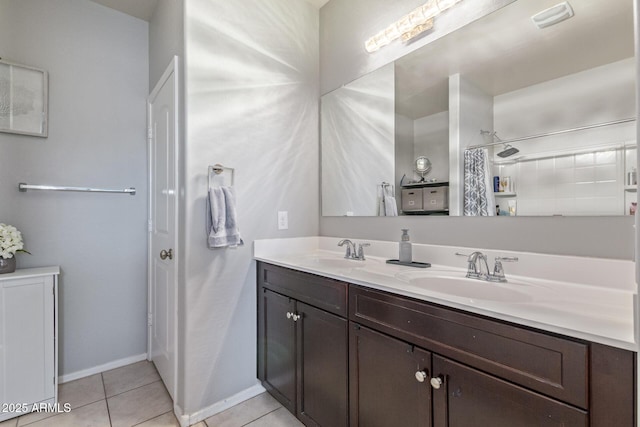 bathroom featuring a sink, double vanity, tile patterned flooring, and baseboards