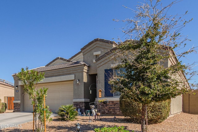 view of front of property with a garage, concrete driveway, stone siding, a tiled roof, and stucco siding